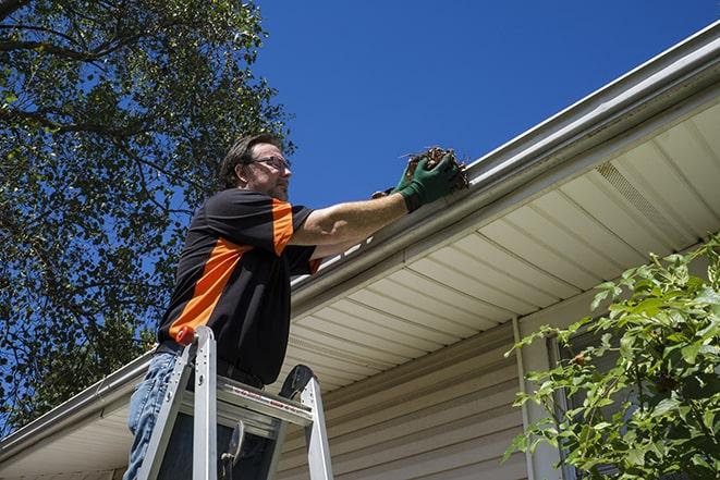 a maintenance worker fixing a leaking gutter in Arlington